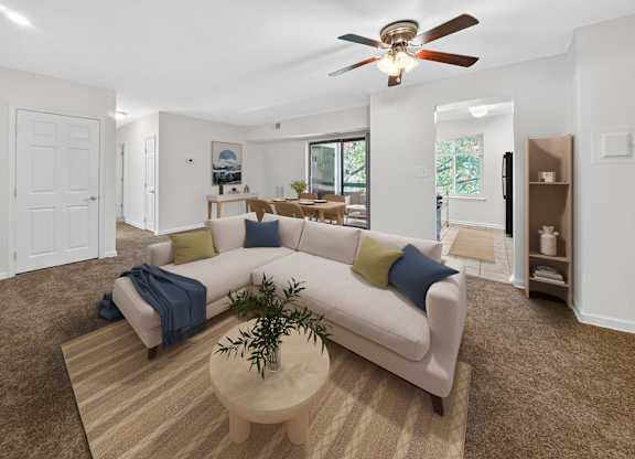 A living room with a white couch and a ceiling fan.