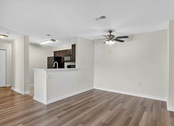 A room with a ceiling fan and a white counter.