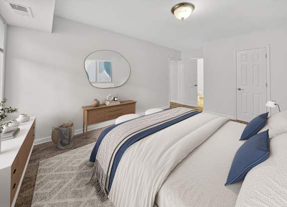 A bedroom with a large bed and a mirror on the wall.