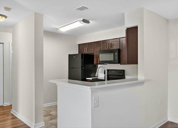 A kitchen with white cabinets and appliances.