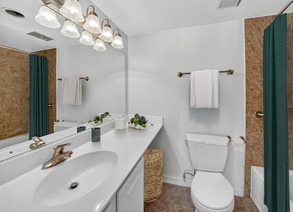 A bathroom with a white toilet and a white sink.