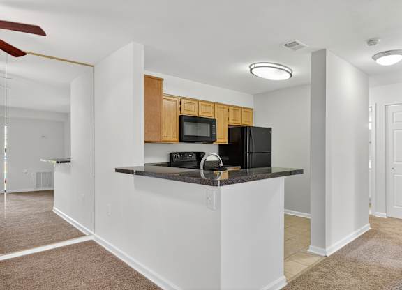 A kitchen with a white counter and brown cabinets.