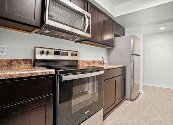 a kitchen with stainless steel appliances and dark wood cabinets