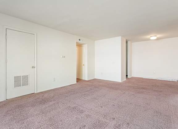 A room with a carpeted floor and white walls.