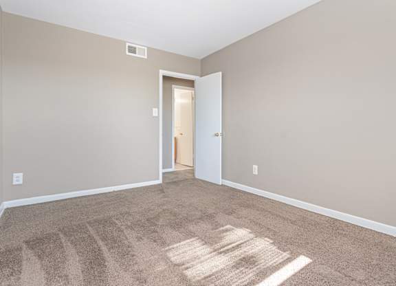 A room with a carpet and a door.