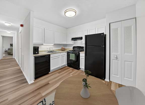 A kitchen with black appliances and white cabinets.