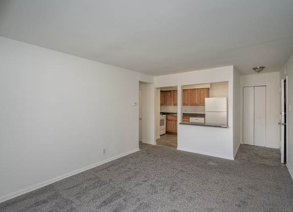 A large empty room with a carpeted floor and white walls.