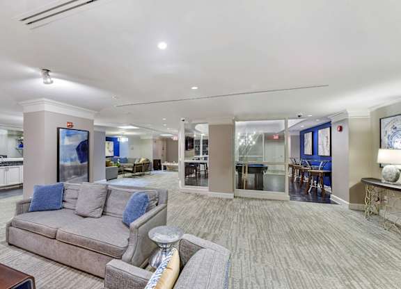 A spacious living room with a grey couch and a television.