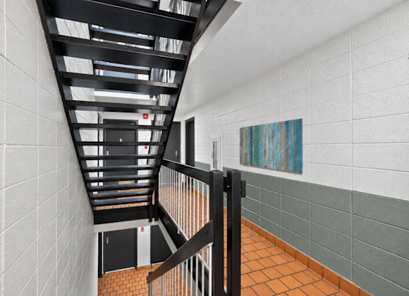 A staircase with a black railing and a white wall.