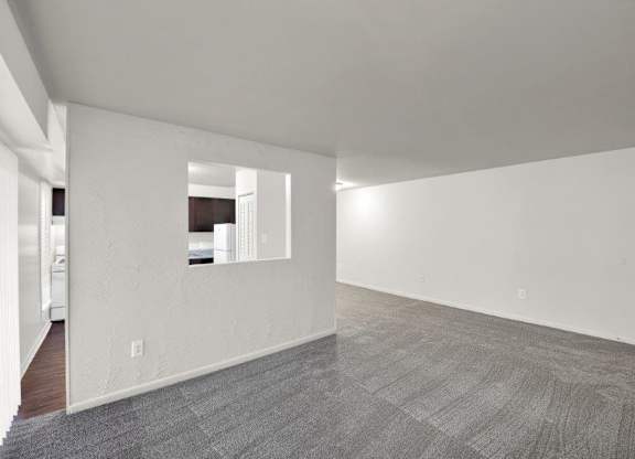a large empty room with white walls and a tile floor