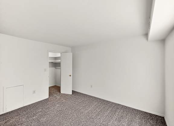 A room with white walls and carpeted floor.