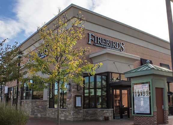 The exterior of a Firebirds restaurant with a tree in front at Brittany Commons Apartments, Spotsylvania, 22553