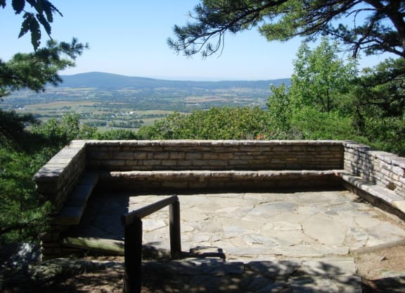 a stone bench with a view of the mountains at The Residences at the Manor Apartments, Frederick, MD