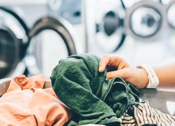 a woman washing clothes in a laundry room