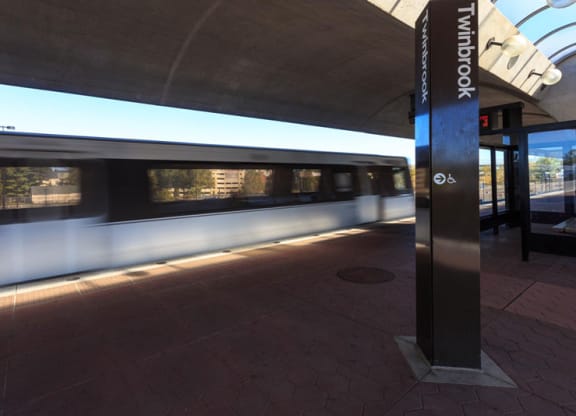 Twin book metro sign with metro rail train in background at The Forest Apartments, Rockville, Maryland