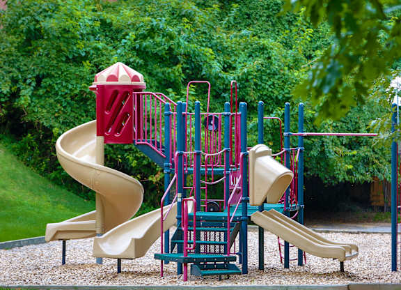 a playground with a slide and other toys in a park