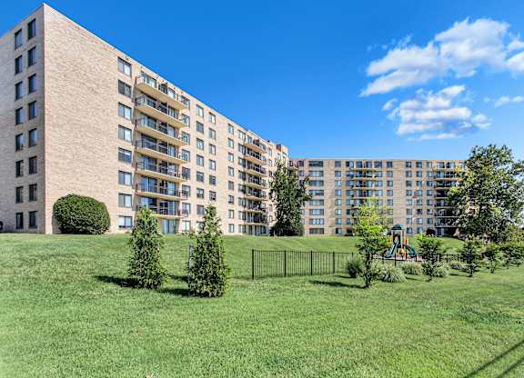A large apartment complex with a green lawn in front.