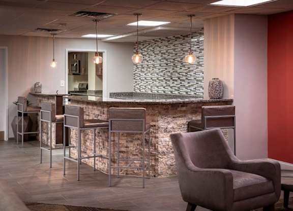 A room with a stone wall and a bar area.