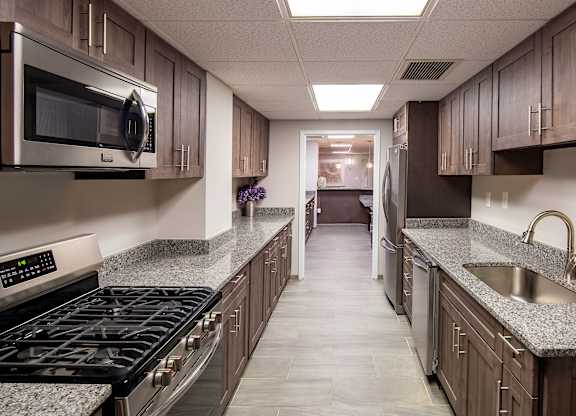 A kitchen with a black stove top oven and a microwave above it.