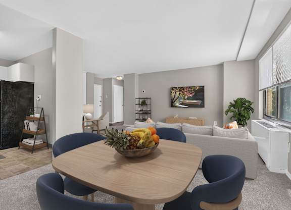 A modern dining room with a wooden table and blue chairs.