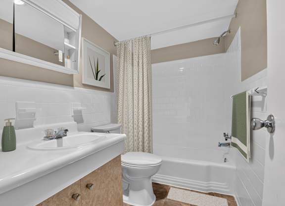 A white toilet sits in a bathroom next to a bathtub.