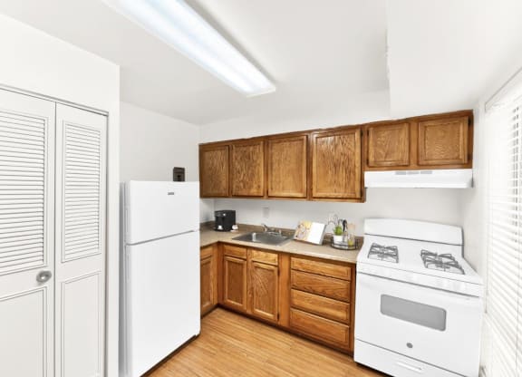 a kitchen with white appliances and wooden cabinets