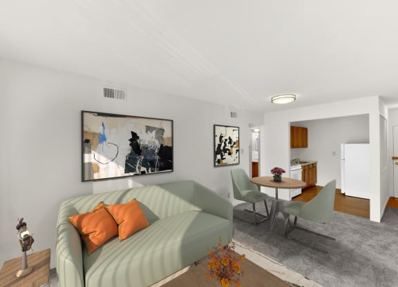 a living room with a green couch and a table with chairs