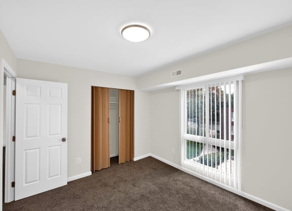 a bedroom with a large window and a white door