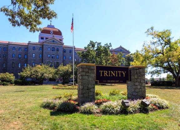 a sign for trinity college in front of a building