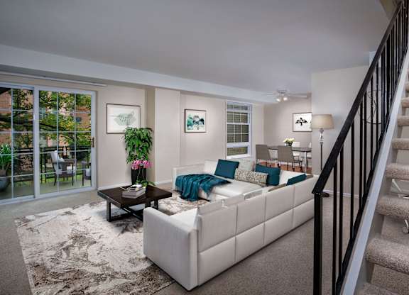 a living room with a white couch and a staircase
