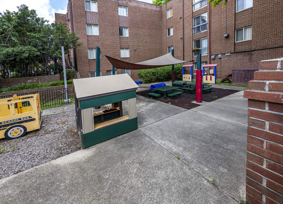 a play area with a hot dog cart in front of an apartment building