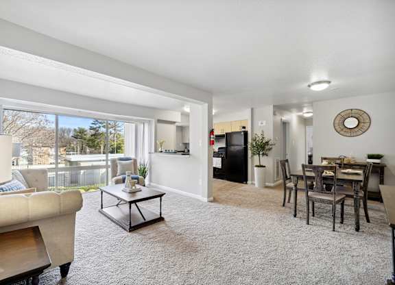 A living room with a couch, a coffee table, and a dining table.