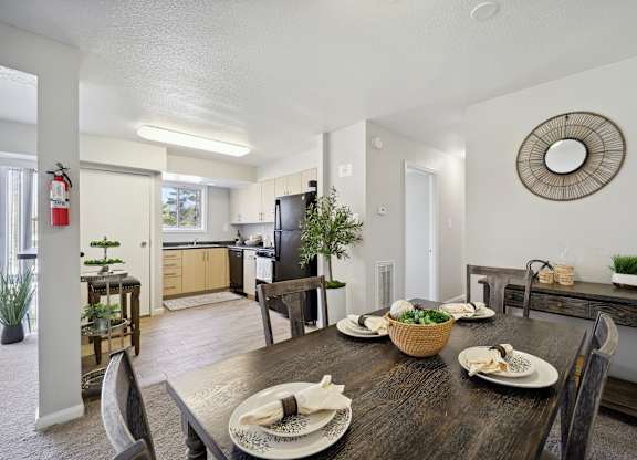 A dining room with a wooden table set for a meal.