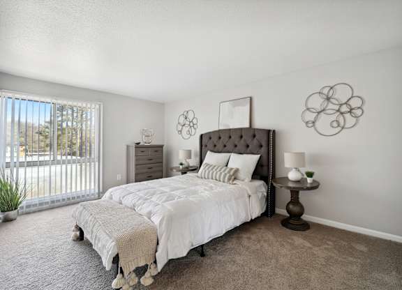 A bedroom with a large bed and a window with a view of the outside.
