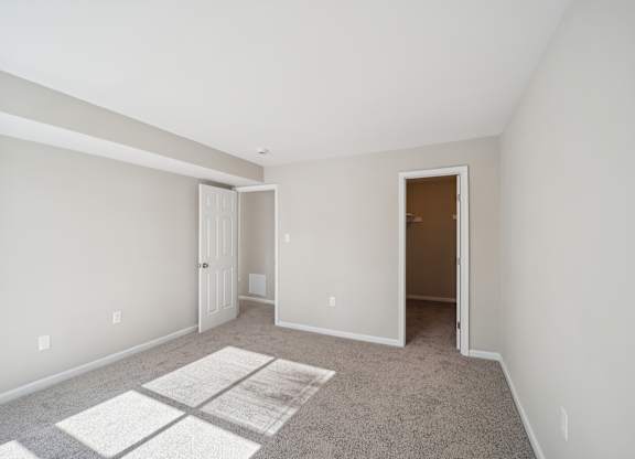 A room with a carpet and two doors.