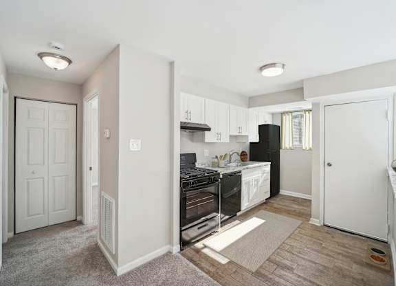 A kitchen with white cabinets and a black stove top oven.