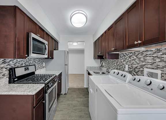 Kitchen With White Cabinetry And Appliances at Aspen at Lake Trail, Columbia, MD 21045