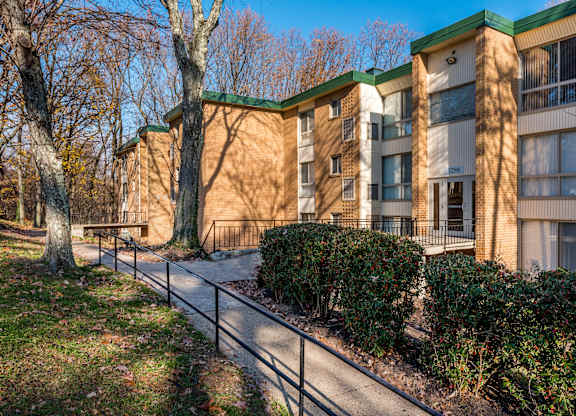 A building with a green roof and a fence in front of it.