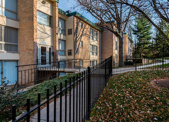 A brick building with a black fence in front of it.