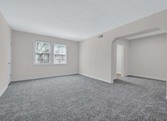 Spacious living room with carpeting and alcove at Highland Ridge Apartments, Capitol Heights, 20743