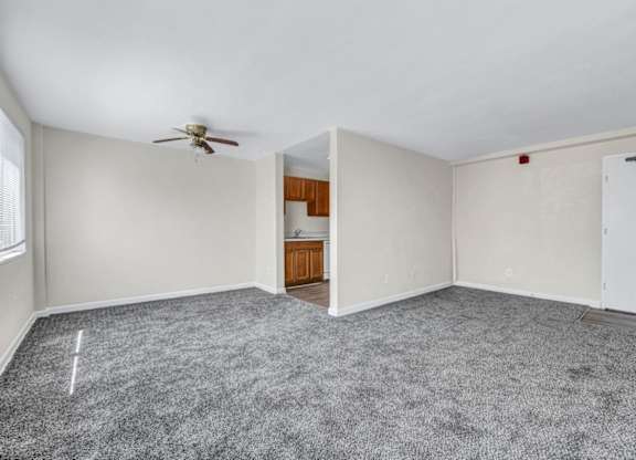 Open concept living room with adjacent kitchenette at Highland Ridge Apartments, Capitol Heights, Maryland