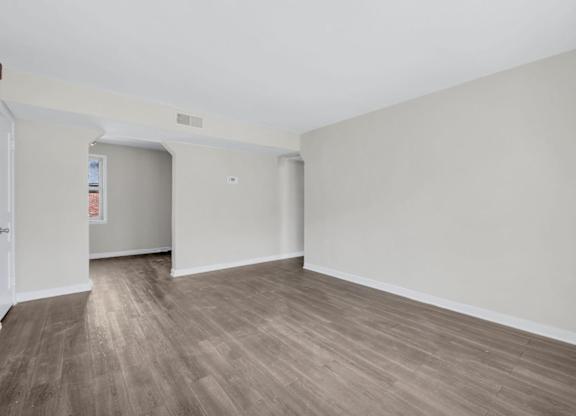 Empty living and dining space with woodstyle flooring at Highland Ridge Apartments, Capitol Heights, 20743