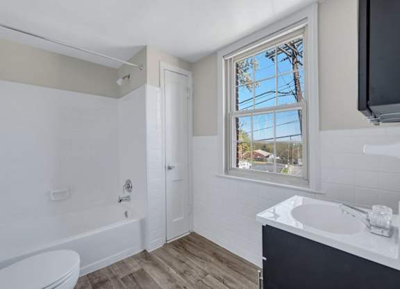 Bathroom with white tub and vanity at Highland Ridge Apartments, Capitol Heights, Maryland
