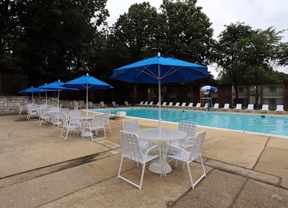 A poolside area with chairs and umbrellas.