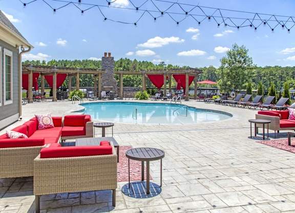 a swimming pool with red chairs and tables around it at Century Lakeshore Crossings, Birmingham, 35211