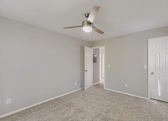 Empty room with a ceiling fan and carpeted floor at Keita 1875, Georgia