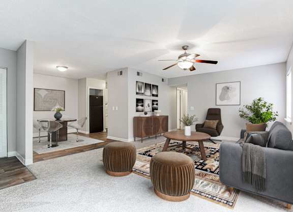 A living room with a grey couch, a wooden coffee table, and a ceiling fan.