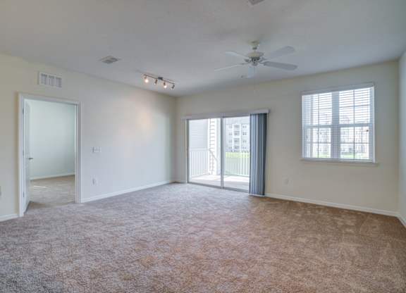 a bedroom with a ceiling fan and a door leading to a balcony  at Century Avenues, Lakeland, FL
