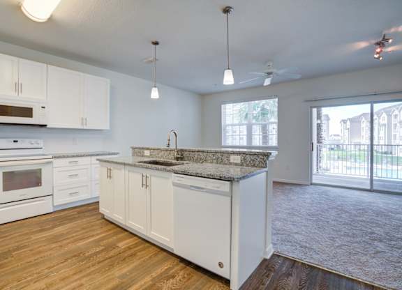 a kitchen and living room with a sliding glass door to a balcony  at Century Avenues, Lakeland, Florida