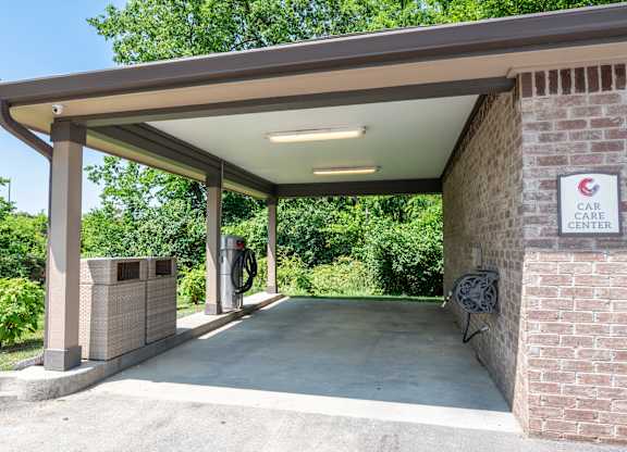 a gas station with a bench and a trash can in front of it at Century Belmont Station, Louisville, Kentucky